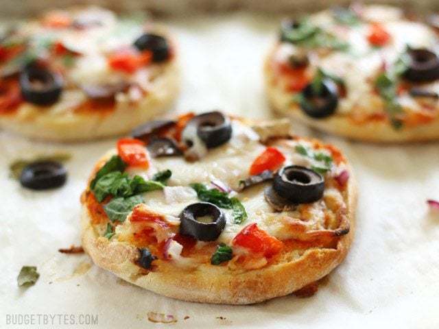 Baked mini pizzas ready for the freezer on a plate.