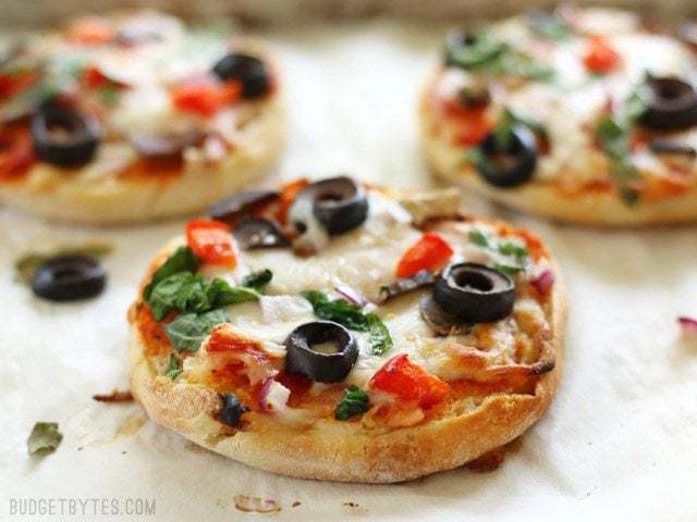 Close up of baked Freezer Ready Mini Pizzas on a parchment lined baking sheet