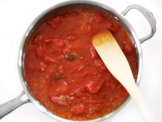 Add Whole Peeled Tomatoes to the skillet with the butter and garlic