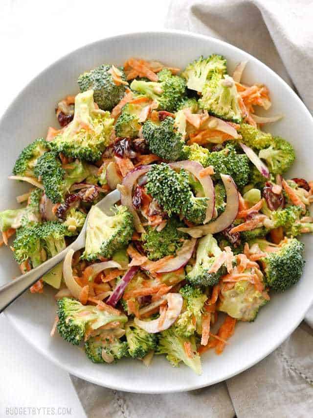 Overhead view of a large bowl full of Broccoli Salad with Honey Yogurt Dressing, a fork in the middle