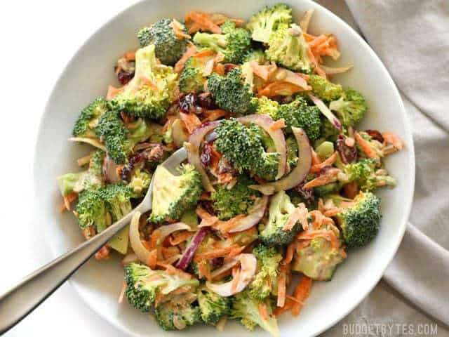 Overhead view of a bowl full of Broccoli Salad with Honey Yogurt Dressing, a fork in the center