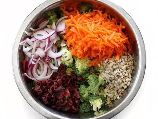 Ingredients for broccoli salad in a metal mixing bowl