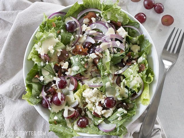 Grape, feta, and bacon salad drizzled with dressing.