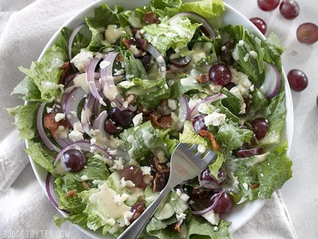 Top view of a plate of Grape Feta and Bacon Salad with a fork 