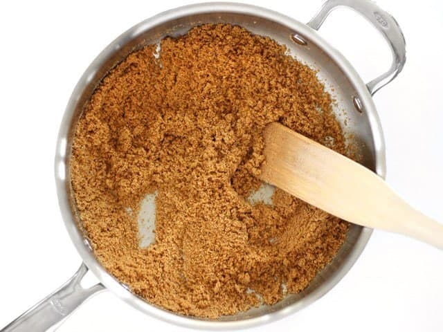 Toast Bread Crumbs in the pan with a wooden spatula