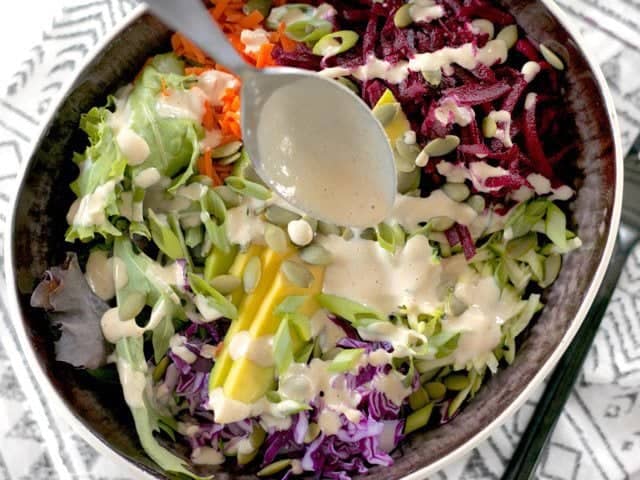 Pouring Tahini Dressing over bowl 