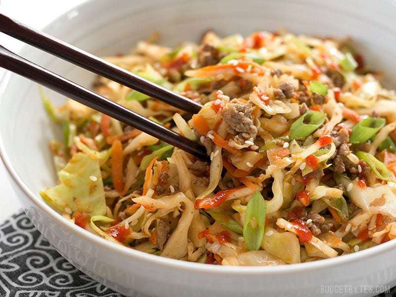 Chopsticks digging into Beef and Cabbage Stir Fry close up