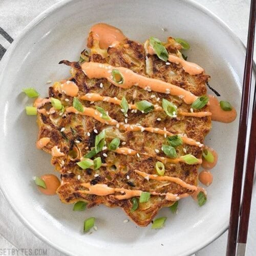 Okonomiyaki cabbage pancake served on a plate.