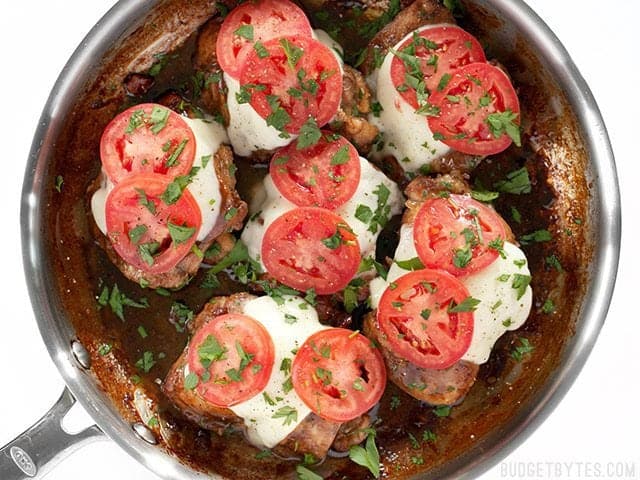 Parsley added on top of melted mozzarella and tomatoes