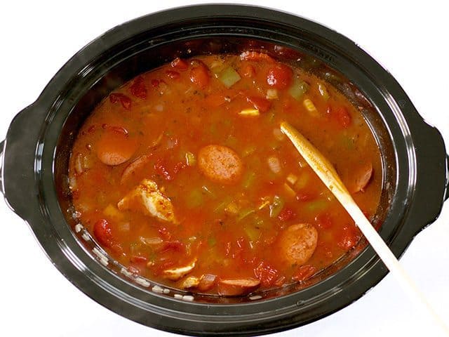 Rice is submerged down in broth in slow cooker 