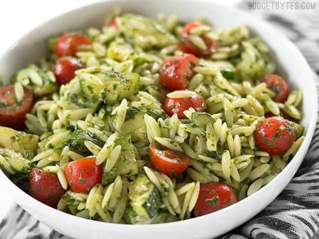 Side view of a bowl full of Zucchini and Orzo Salad with Chimichurri 