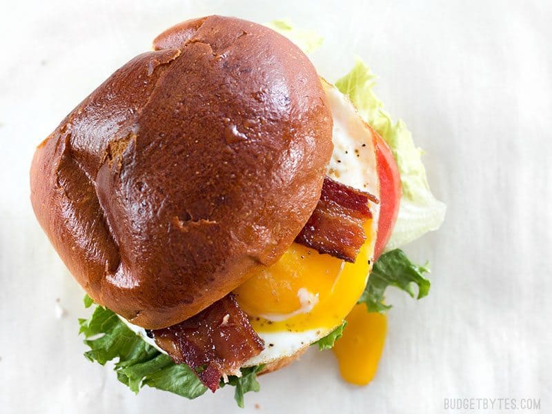 Overhead view of a Brown Sugar Bacon Breakfast Sandwiches with the yolk dripping down the side