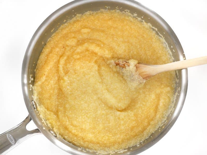 Cooked Grits in pot with a wooden spoon