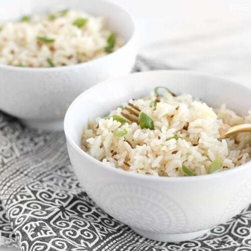 Cumin rice bowls served with a fork.