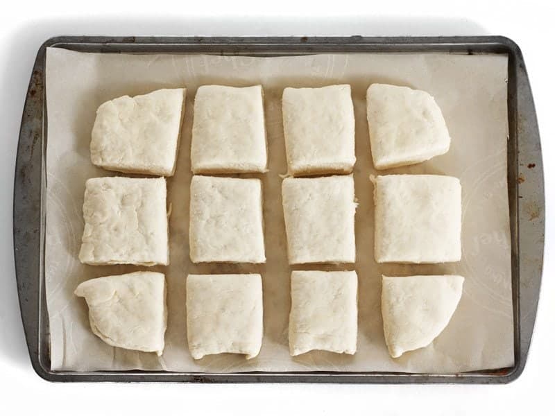 Raw biscuit dough on a parchment lined baking sheet, ready to freeze