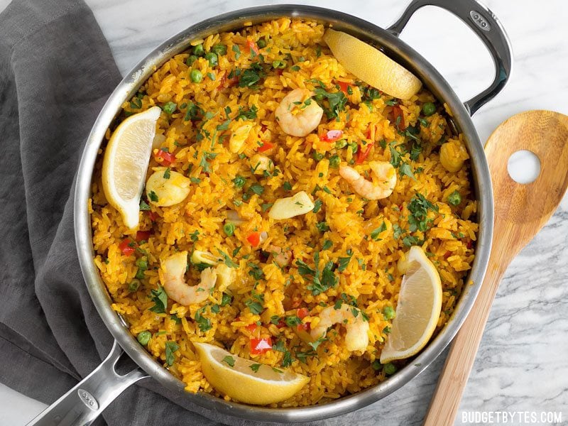 Overhead view of the Seafood Rice Skillet garnished with lemon wedges and parsley