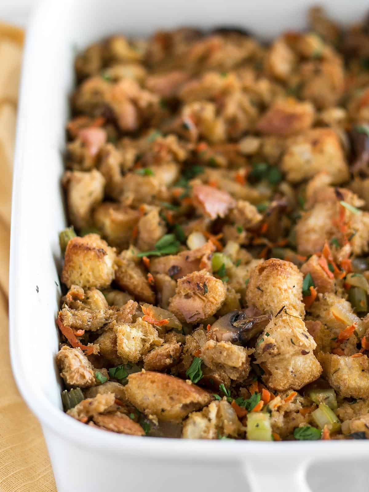 Close up side view of a ceramic casserole dish full of vegetarian stuffing.