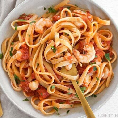 Spicy seafood fettuccine twirled with a fork.