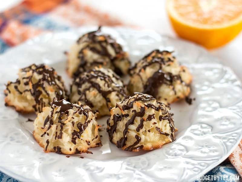 A plate full of Chocolate Glazed Macaroons with a fresh orange in the background