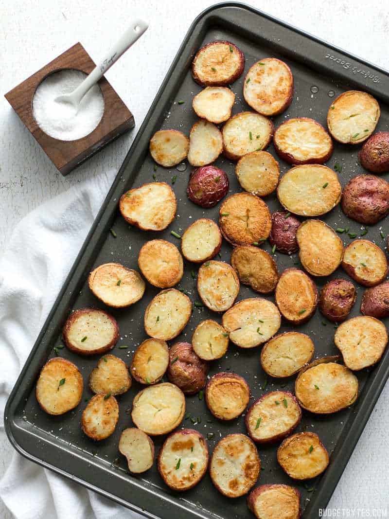 These Salt & Vinegar Roasted Potatoes on baking sheet with a bowl of sauce on the side 