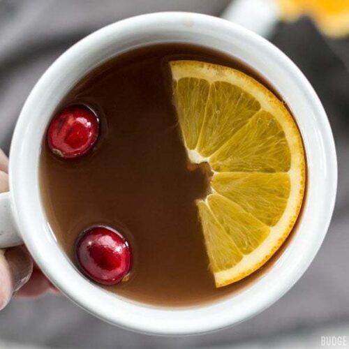 Close up of a slow cooker spiced cranberry cider in a cup.