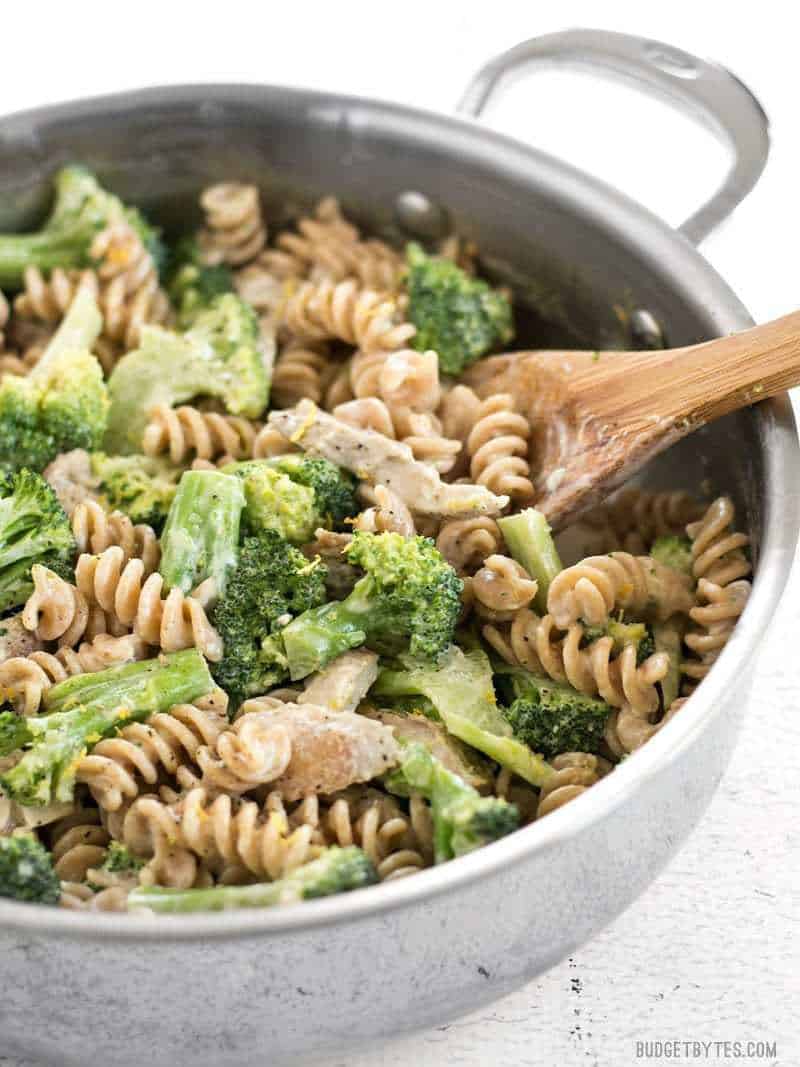 Side view of Chicken and Broccoli Pasta with Lemon Cream Sauce in the skillet with a wooden spoon