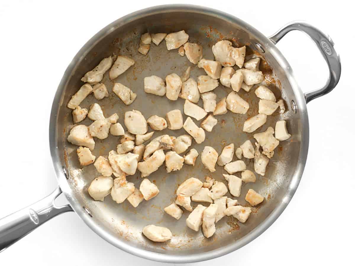 Sautéed diced chicken breast in a skillet.