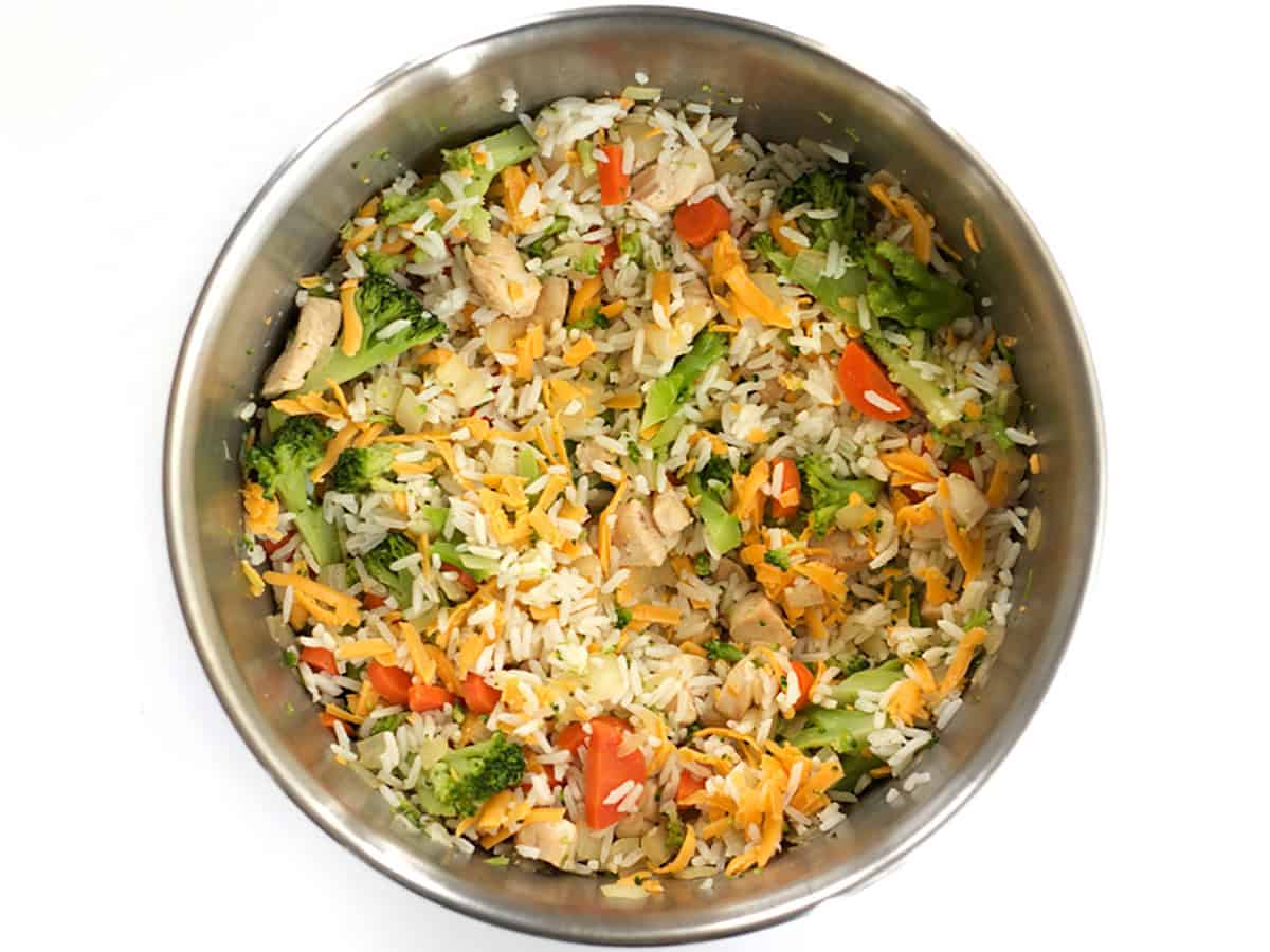 Shredded cheese mixed into the bowl of broccoli, rice, and vegetables. 