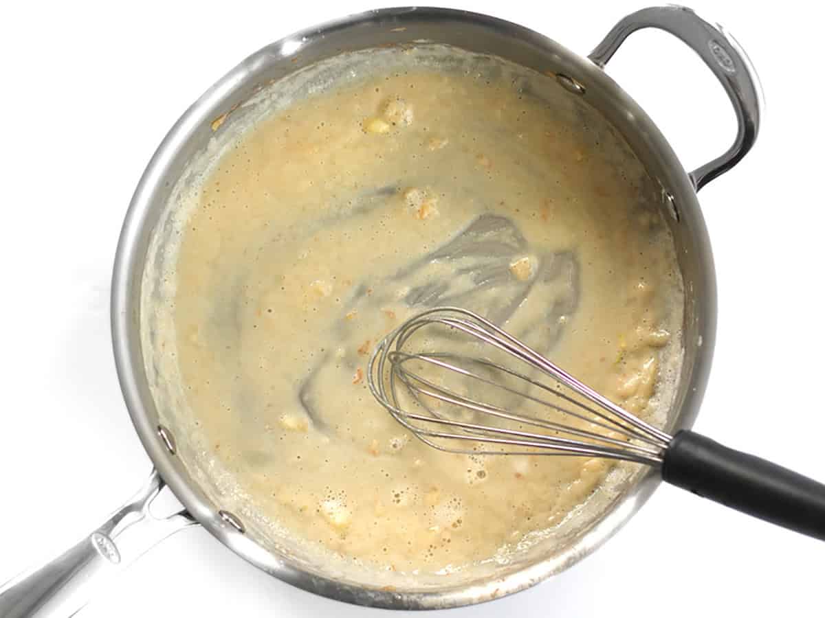 Butter and flour roux in a skillet being whisked.