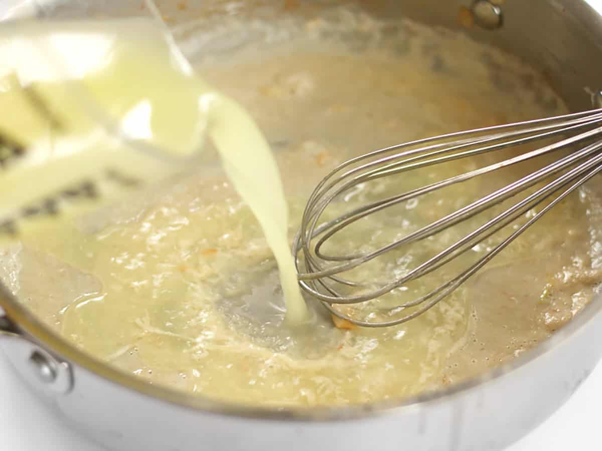 Chicken broth being whisked into the roux.