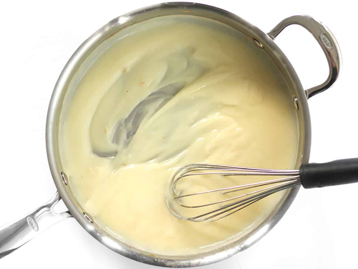 Thickened sauce being whisked in the skillet. 