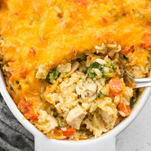 Close up overhead view of a spoon digging into the the chicken and rice casserole.