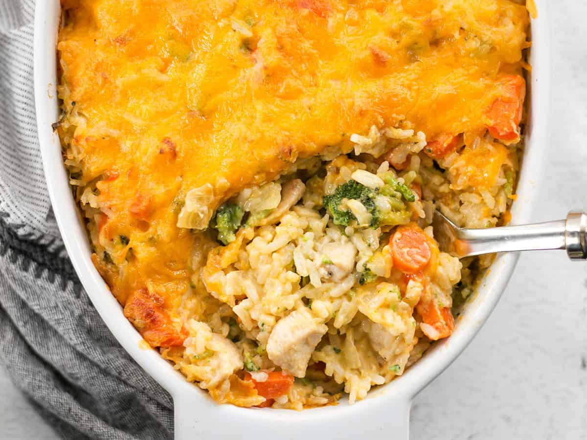 Close up overhead view of a spoon digging into the the chicken and rice casserole.