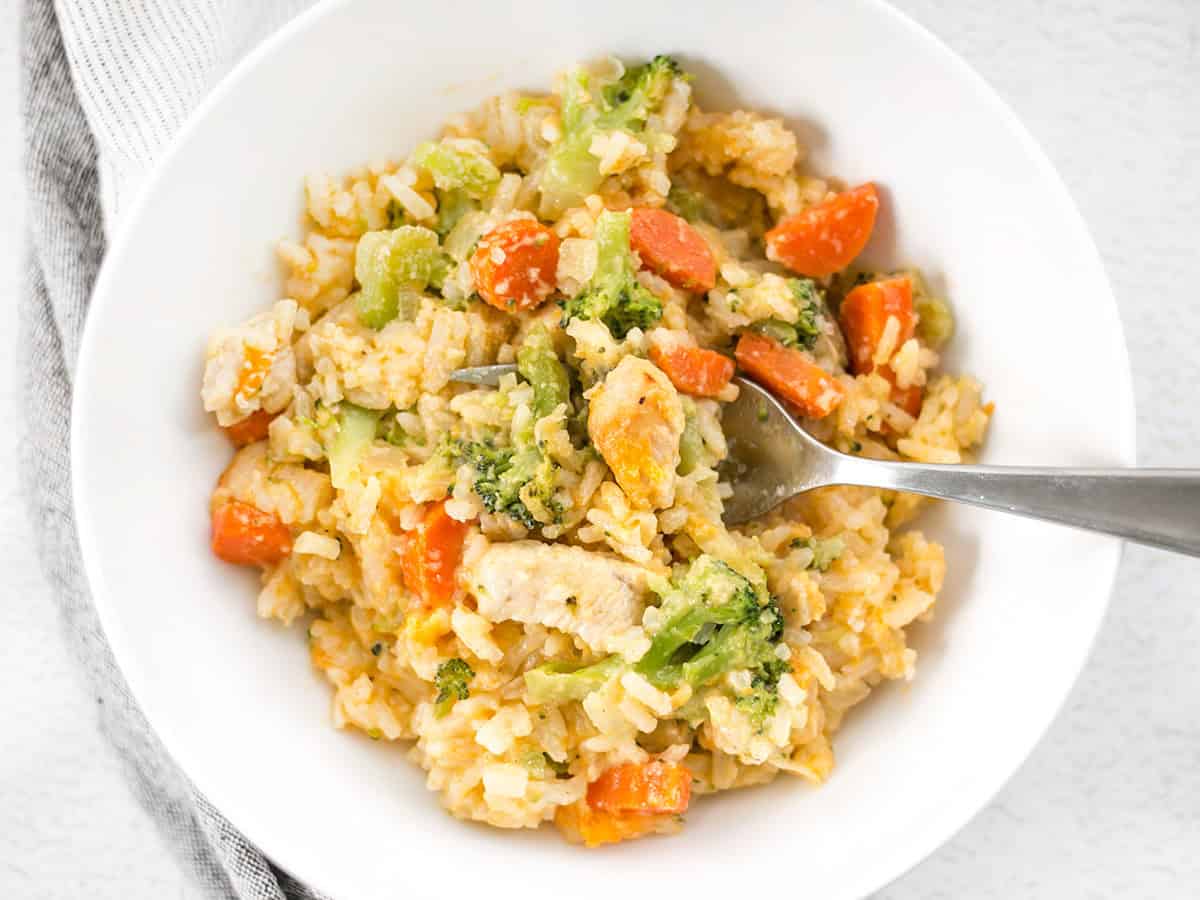 Cheesy chicken and rice casserole in a bowl with a fork. 