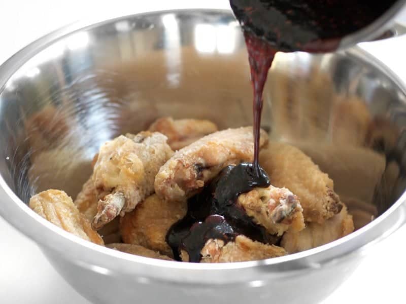 Pour Glaze onto baked chicken wings in the bowl