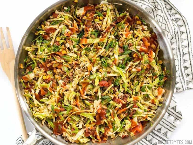 Close up of Southwest Beef and Cabbage Stir Fry in the skillet with wooden fork on the side