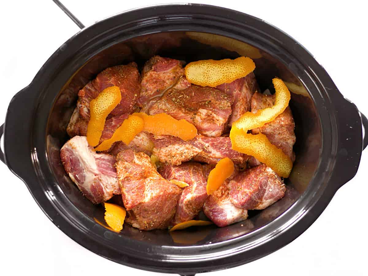 Orange peels on top of the pork in the slow cooker.