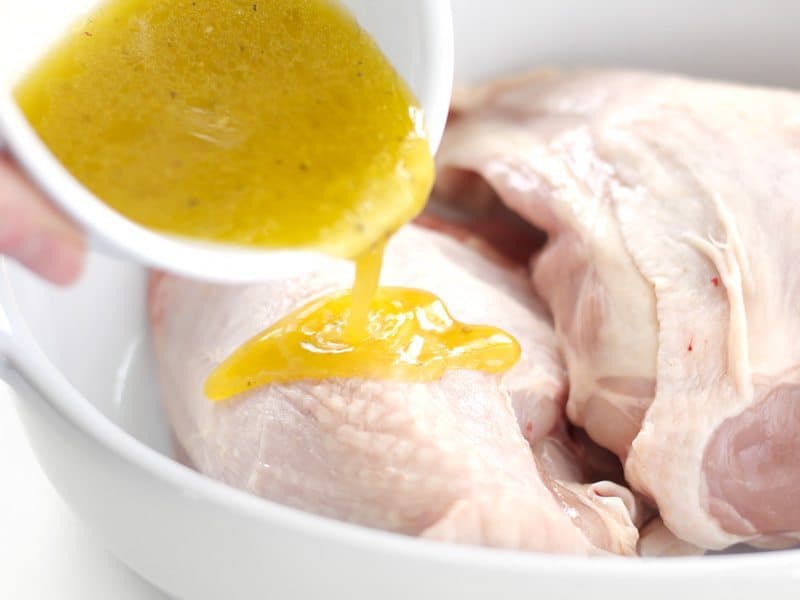 Marinade being poured on Chicken in the casserole dish