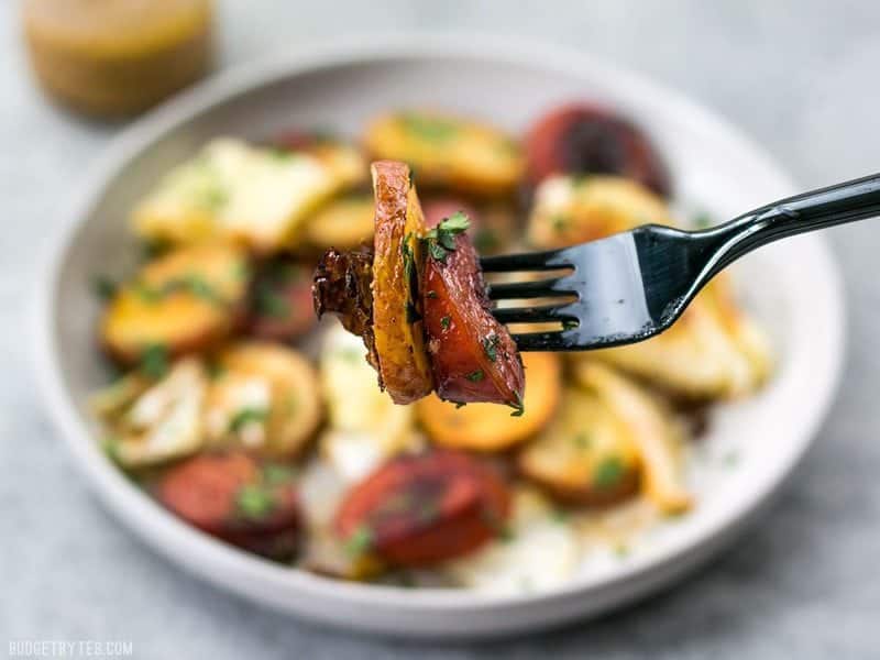 A forkful of Roasted Kielbasa and Cabbage with the plateful in the background