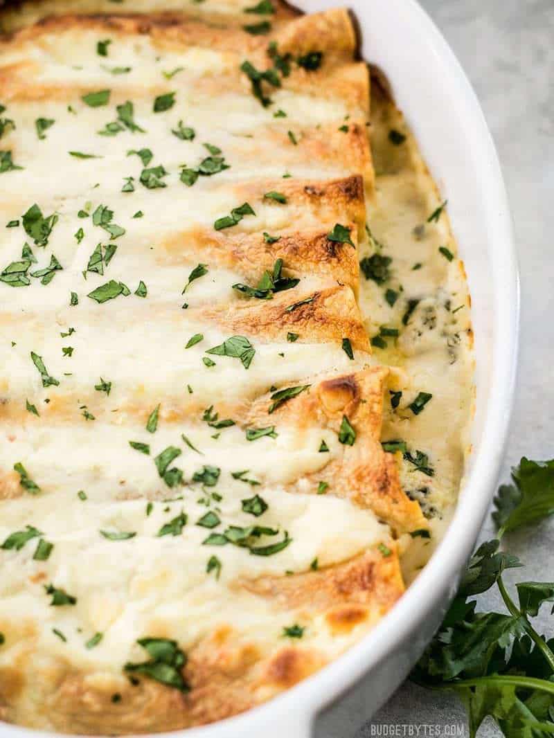 Close up of crispy edges of tortillas in the spinach white bean enchiladas