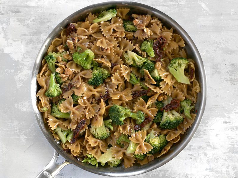 Add Broccoli and Walnuts to cooked pasta in skillet