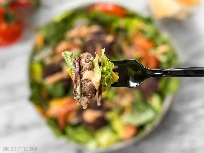 Close up of a forkful of Cheeseburger Salad with animal sauce dressing