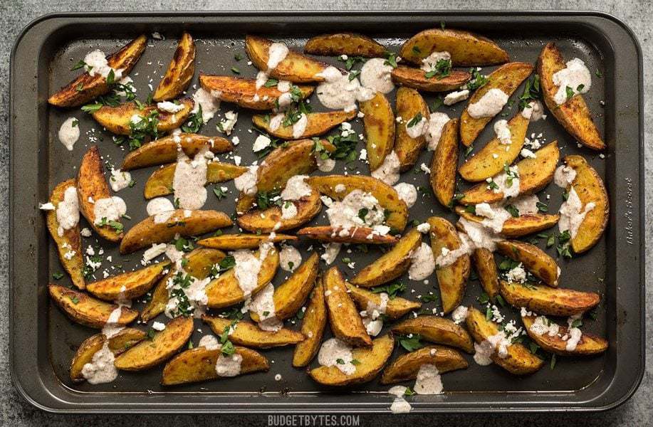 Finished Roasted Potato Wedges with Shawarma Sauce on the baking sheet