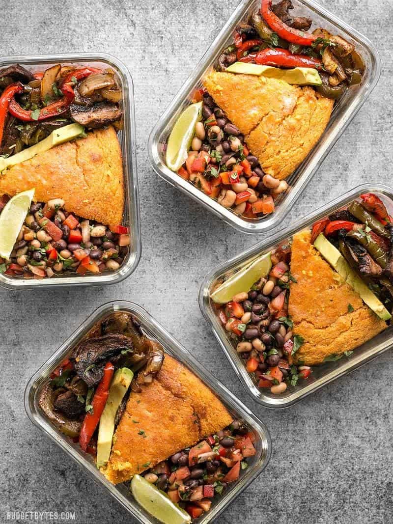 Four glass smoky chipotle portobello fajita meal prep containers scattered on the counter