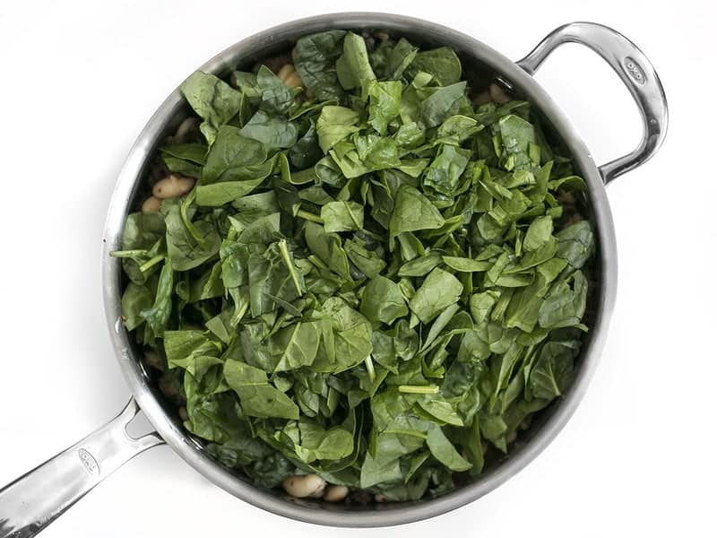 Add Spinach to skillet with sausage and white beans