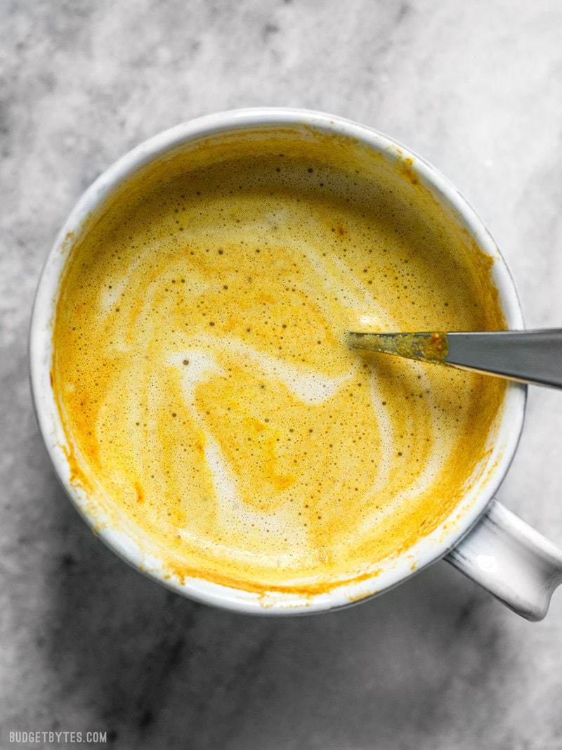 Overhead view of a mug full of Golden Chai with a spoon 