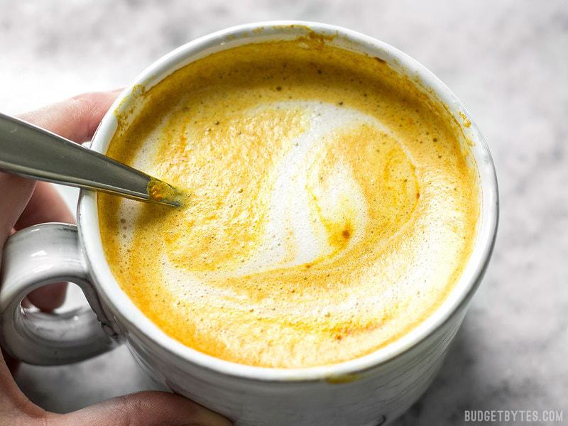 Close up of a mug full of Golden Chai with frothy milk swirled on top