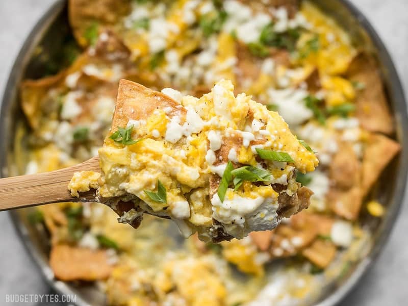 Close up of a spoonful of Green Chile Migas with the pan in background