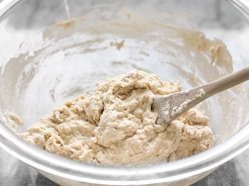 Shaggy Pizza Dough in the bowl with a wooden spoon