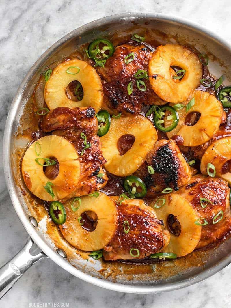 Finished Skillet Pineapple BBQ Chicken in a skillet with green onion and jalapeño sprinkled over top.